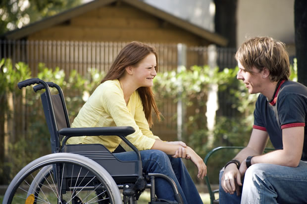 Disabled womain in wheelchair talking with man